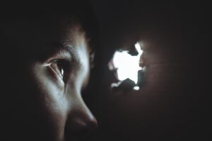 boy looking through hole in box