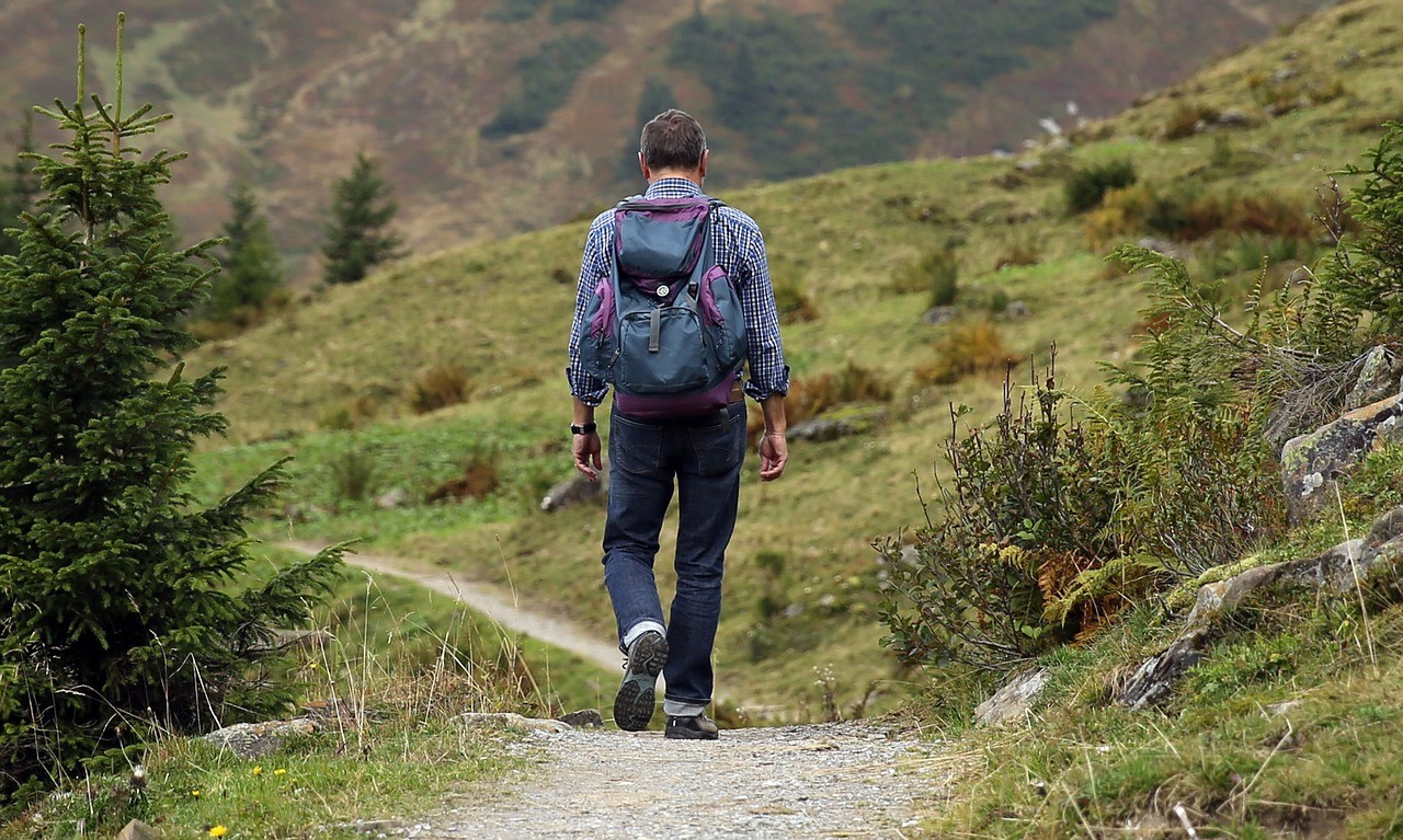 man walking on mountain path