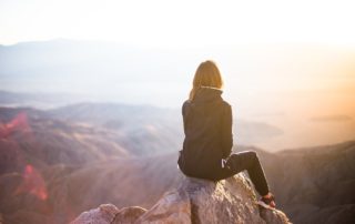 women sitting on mountain top