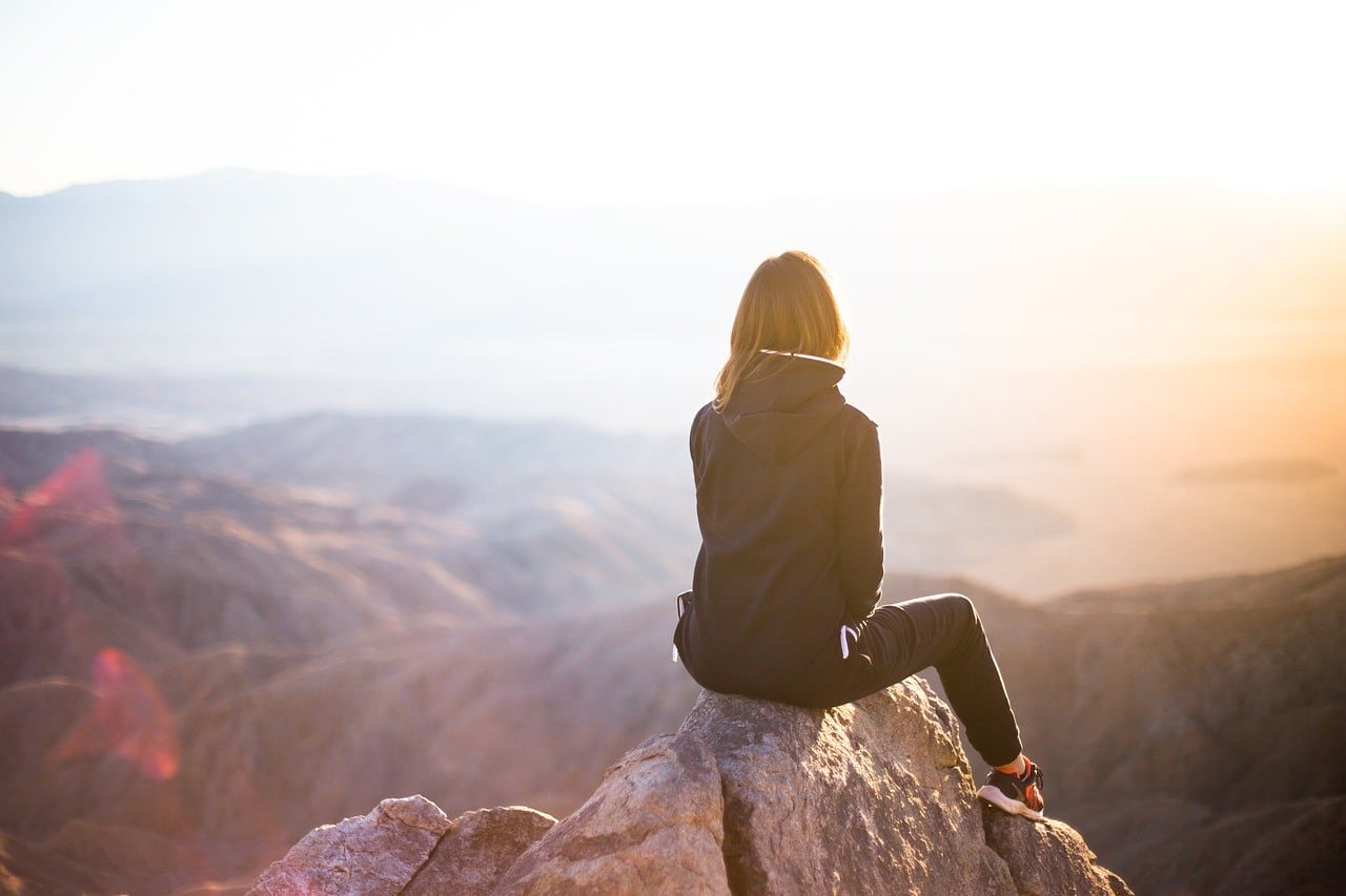 women sitting on mountain top